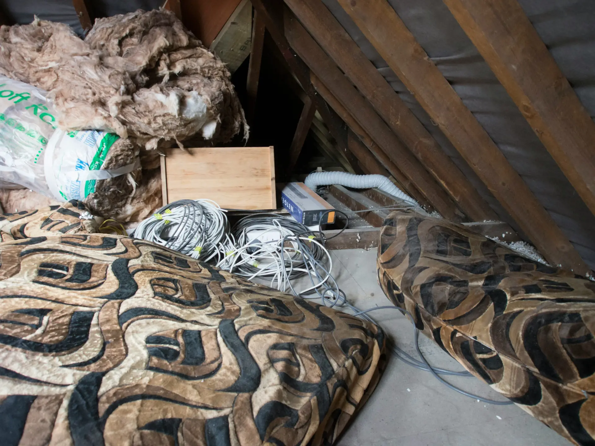 Old, failing insulation with moisture damage and degraded materials exposed during insulation-removal